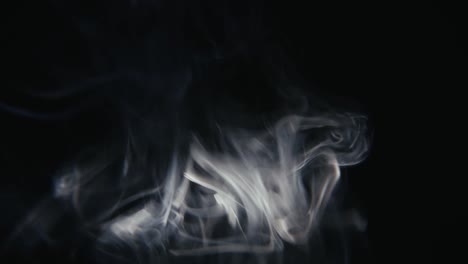 Smoke-rising-in-frame-on-a-black-background