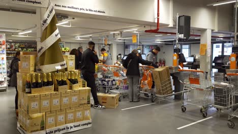Supermarket-customers-at-checkout-counter-at-Colruyt-warehouse