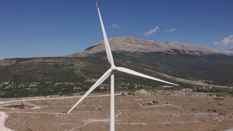Windkraftanlage-Dreht-Sich-Mit-Berg-Im-Hintergrund