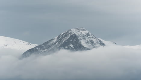 Zeitrafferwolken-Bedecken-Schneebedeckte-Berggipfel,-Winter-Bewölkt