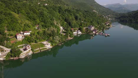 Aerial-view-of-the-settlements-on-the-shores-of-Lake-Jablanica-in-Bosnia,-drone-shot-of-the-bridge-built-over-the-river