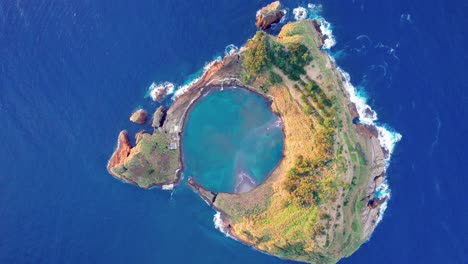 High-angle-aerial-riser-above-vegetated-uninhabited-Vila-Franca-Islet,-Azores