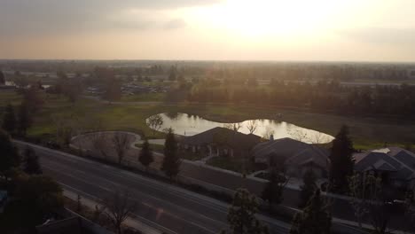 Cinematic-Aerial-Drone-Shot-of-Golf-Course-Lake-During-Magical-Golden-Hour