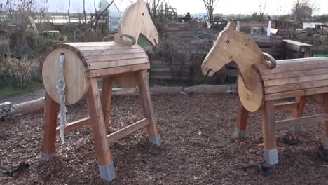 2-wooden-horses-in-a-playground-in-a-garden-in-Tempelhof-Aiport-Berlin-Neukoelln-Germany-30-fps-HD-5-secs