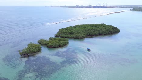 Small-tropical-mangrove-island,-boat-ride-in-turquoise-ocean-water,-aerial-orbit