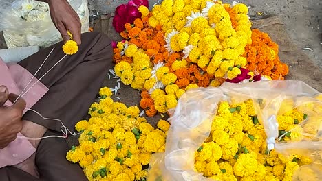 A-shopkeeper-is-making-fresh-flower-garlands-on-Street-Road