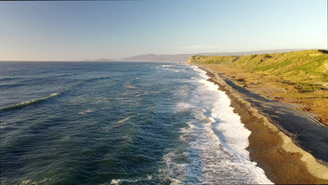 Vorwärts-Dolly-Natur-Strand-Chiloé-Insel-Chonchi-Chile-Sonne-Sonnenuntergang-Stein-Felsen-Welle-Grüner-Hügel