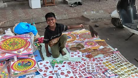 Wide-shot,-a-young-boy-is-selling-decorative-items-on-the-street-road-to-make-a-living