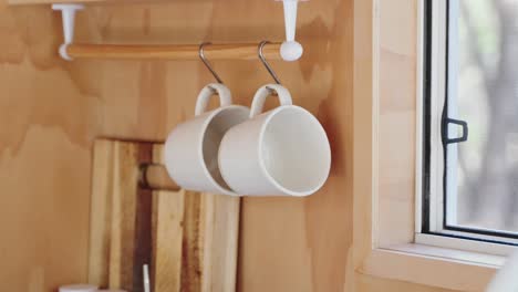 Person-grabbing-coffee-mug-in-wooden-tiny-cabin-kitchen