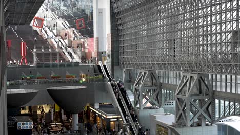 Busy-Kyoto-Station-with-people-going-up-and-down-on-escalator,-Japan