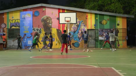 Schwarze-Männliche-Athleten-Spielen-Nachts-Als-Mannschaftsbasketball-Bei-Sportlichen-Aktivitäten-Im-Freien
