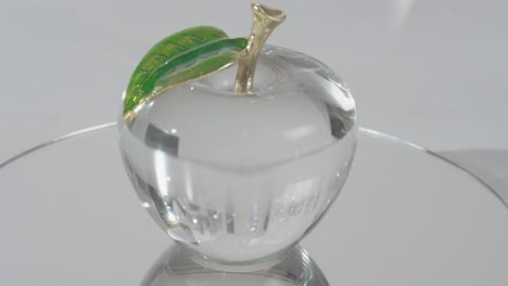 Crystal-Glass-apple-on-top-of-a-mirror-shinning-light-through