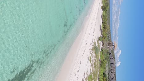 Vertical-backwards-flight-showing-paradisaical-sandy-beach-with-turquoise-water-in-Pedernales,-Dominican-Republic
