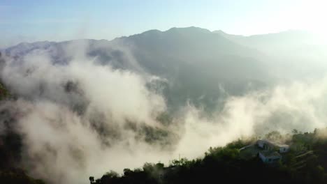 aerial-drone-camera-cinematic-shot-A-lot-of-fog-and-mountains-are-visible-and-hills-houses-are-also-there