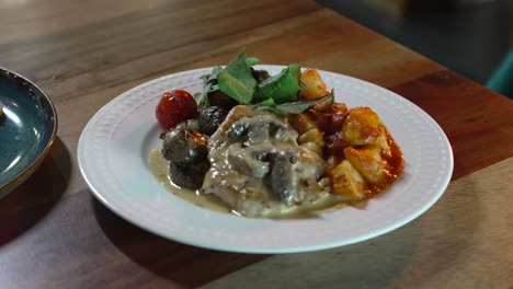 Delicious-chicken-dish-recipe-with-mushroom-cream,-potatoes-and-salad-on-a-restaurant-table