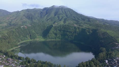 Luftaufnahme-Eines-Wunderschönen-Sees,-Umgeben-Von-Hügeln-Und-Wäldern-Am-Morgen