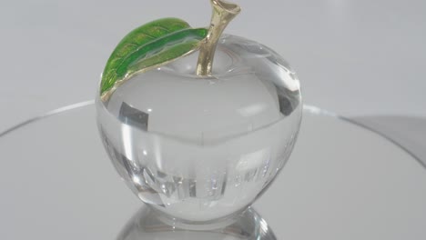 Crystal-Glass-apple-on-top-of-a-mirror-shinning-light-through