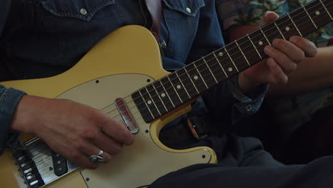 Man-plays-vintage-cream-colored-Fender-Telecaster-guitar,-close-up