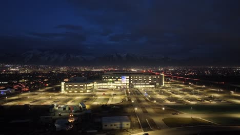 Primary-Children's-Hospital-in-Lehi,-Utah---nighttime-aerial-push-in-flyover