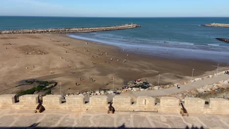 Many-North-African-people-playing-happily-in-wide-beach-of-Rabat-at-sunny-day