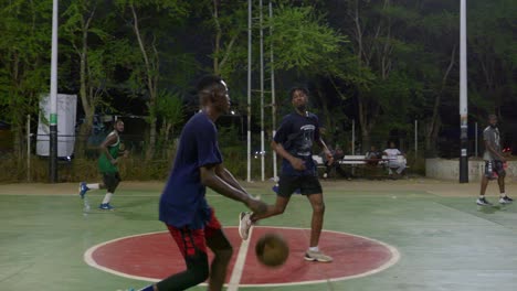 Slow-motion-of-black-athletes-play-basketball-outdoors-at-noght-as-team