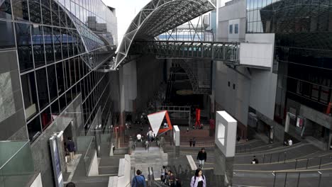POV-going-down-escalator-at-busy-main-Kyoto-station-in-Japan