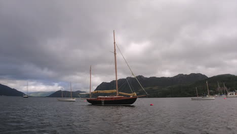 View-from-boat:-Drifting-past-large-two-mast-sailing-yacht-under-cloud