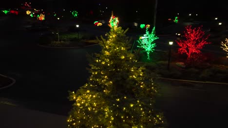 Aerial-orbiting-shot-of-lighting-Christmas-tree-and-Christmas-decoration-along-American-road