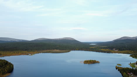 Aerial-descends-to-picturesque-countryside-lake-in-flat-boreal-forest