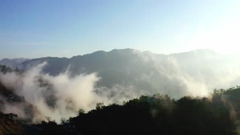 Luftdrohnenkamera-Filmaufnahme,-Viel-Nebel-Ist-Aufgrund-Der-Sonnenstrahlen-Sichtbar-Und-Ist-Auf-Den-Büschen-Auf-Den-Hügeln-Sichtbar