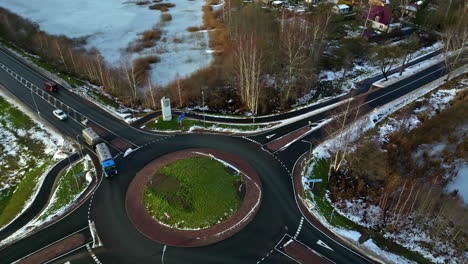 Truck-entering-roundabout-in-rural-area-in-winter-season,-aerial-view