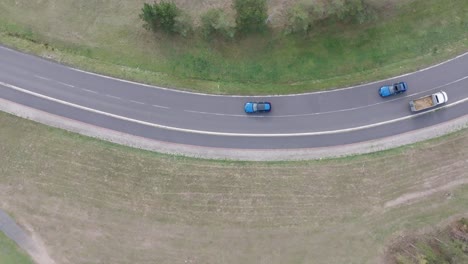 Flying-above-similar-blue-cars-drive-on-highway-and-reach-intersection