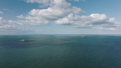 4K-Aerial-Approaching-Farne-Island-Lighthouse,-United-Kingdom-on-a-sunny-afternoon