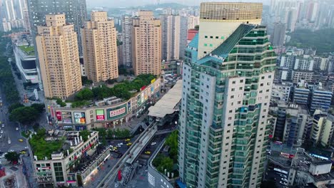 Stunning-aerial-view-of-downtown,-Jiulongpo-square-plaza-subway-train-station-and-skyscrapers-in-Chongqing,-China