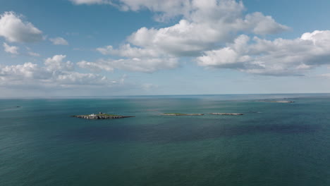 4K-Aerial-of-Farne-Island-Lighthouse,-United-Kingdom-on-a-sunny-afternoon