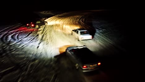 Aerial-follow-shot-of-extreme-winter-drift-competition-during-nighttime