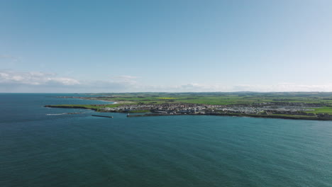 4K-Aerial-of-Seahouses-harbour,-United-Kingdom-on-a-sunny-afternoon