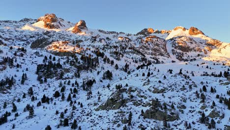 Drone-footage-of-big-snowy-mountains-with-a-golden-sun-in-the-Pyrenees-mountains