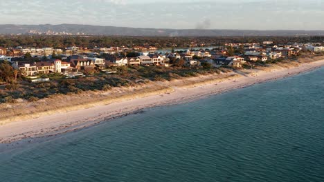 Wide-aerial-of-Tennyson-Beach-suburb-with-Adelaide-city-in-background,-South-Australia
