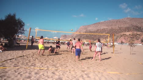 Grupo-De-Personas-Jugando-Voleibol-De-Playa-En-Ambiente-De-Verano,-Cámara-Lenta