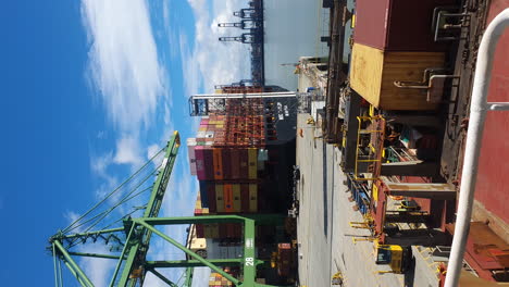 Crane-unloading-containers-off-cargo-ship,-Panama-Canal-port,-vertical-format