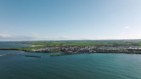 4K-Slow-Orbit-of-Seahouses-harbour,-United-Kingdom-on-a-sunny-afternoon