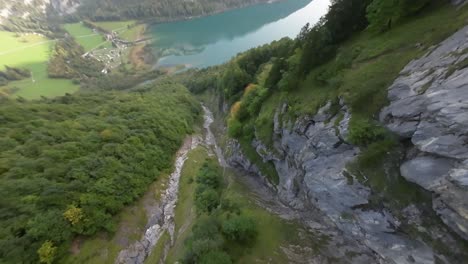 FPV-drone-descend-over-Switzerland-mountain-gorge-and-reach-turquoise-water-lake