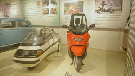 Das-Elektrische-Miniauto-City-El-Und-Der-Roller-BMWC1-Sind-Im-Museum-Ausgestellt