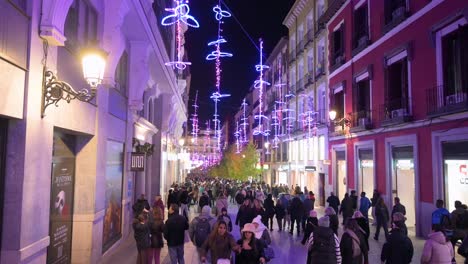 People-walk-through-a-crowded-pedestrian-street-illuminated-with-Christmas-purple-lights-during-the-Christmas-holiday