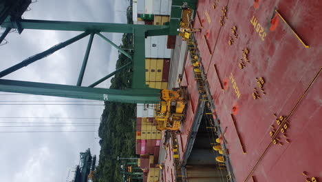 Panama-Canal-terminal-workers-supervise-lift-moving-heavy-equipment,-vertical
