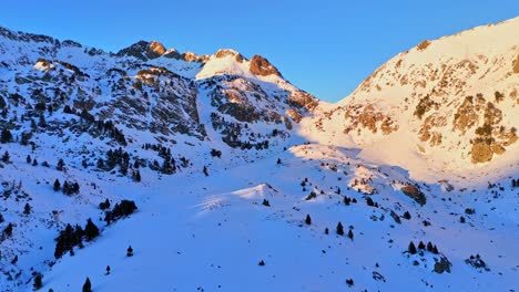Drone-footage-of-snowy-mountains-with-a-golden-sun-in-the-Pyrenees-mountains