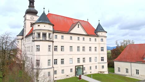 Schloss-Hartheim-Castle-Against-Cloudy-Sky-In-Alkoven,-Upper-Austria---Aerial-Drone-Shot