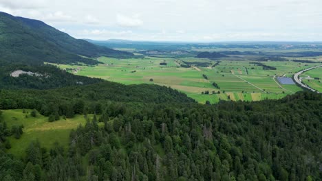 Aerial-of-green-fields-in-a-Bavarian-town,-Garmisch-Partenkirchen-Bavarian-village-in-the-Alps-mountains,-Germany