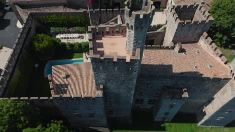 Aerial-revealing-shot-of-Chateau-de-Pouzilhac-with-a-tower-and-private-pool
